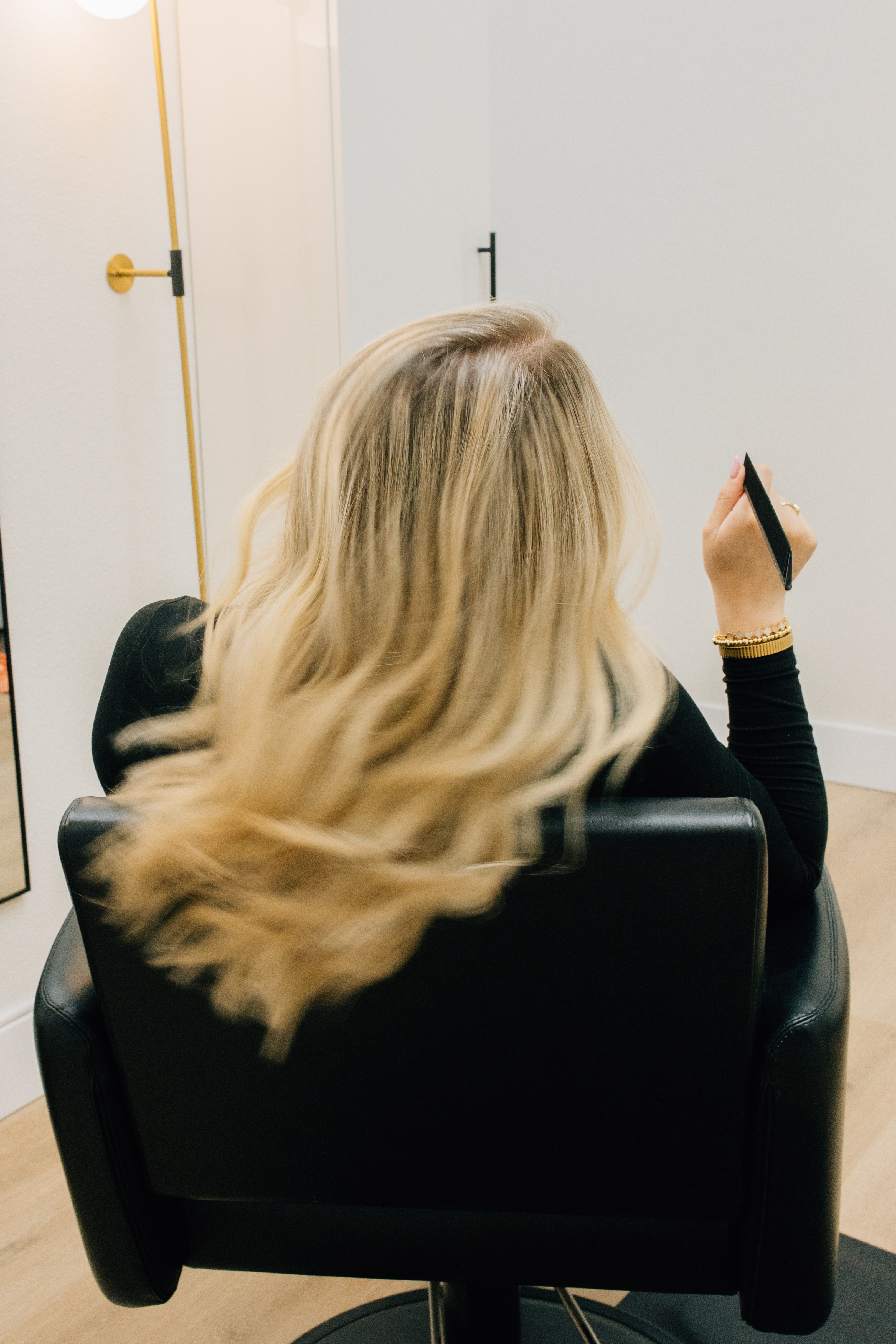 Soft blonde hair styled in flowing waves at the salon